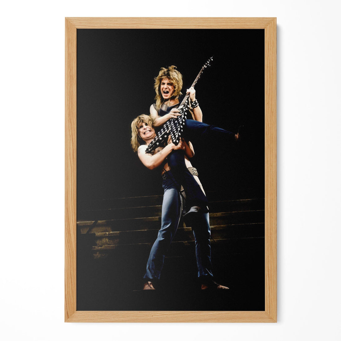Restored 1982 concert print of Ozzy Osbourne and Randy Rhoads hanging in a natural oak frame on a plain wall