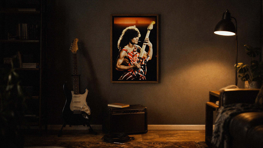 Framed Eddie Van Halen guitar wall art print hanging above an electric guitar and amplifier in a dark home music room