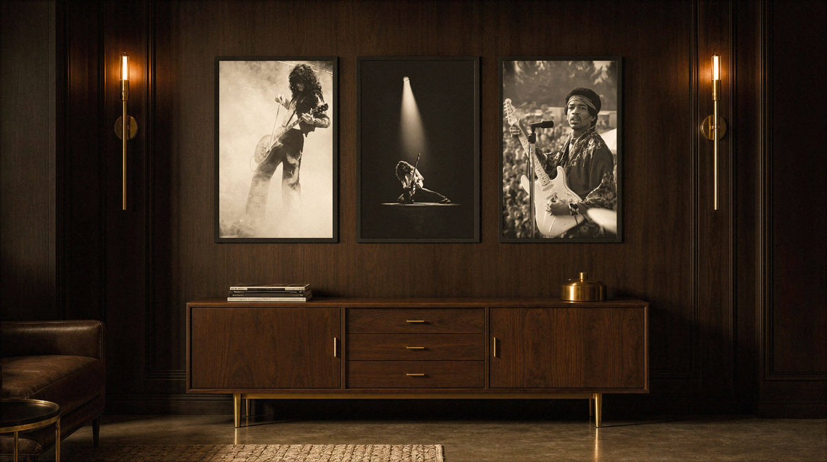Three black and white music posters hung in a row above a walnut credenza