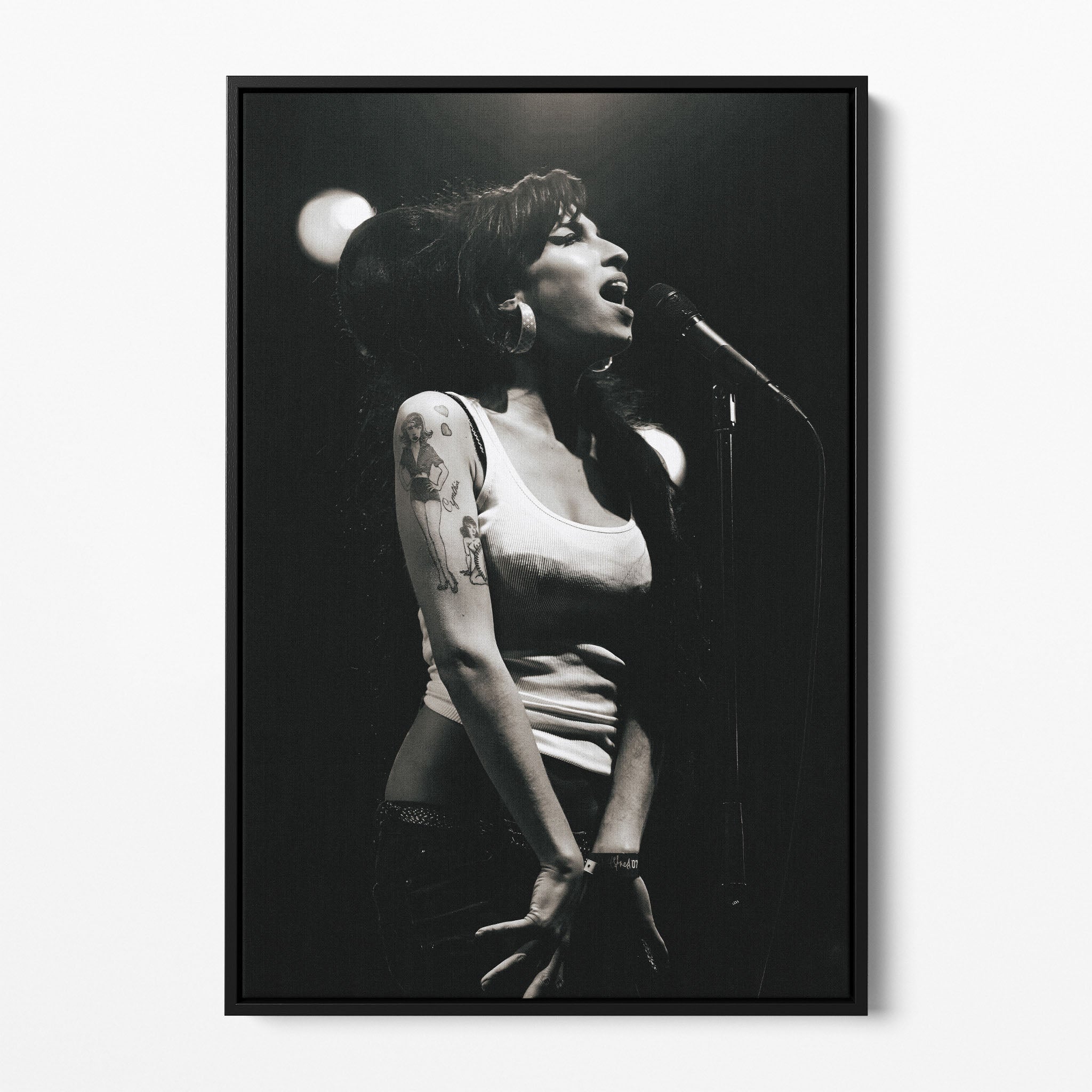 Front view of the Amy Winehouse 2007 black and white canvas in a sleek black floating frame.