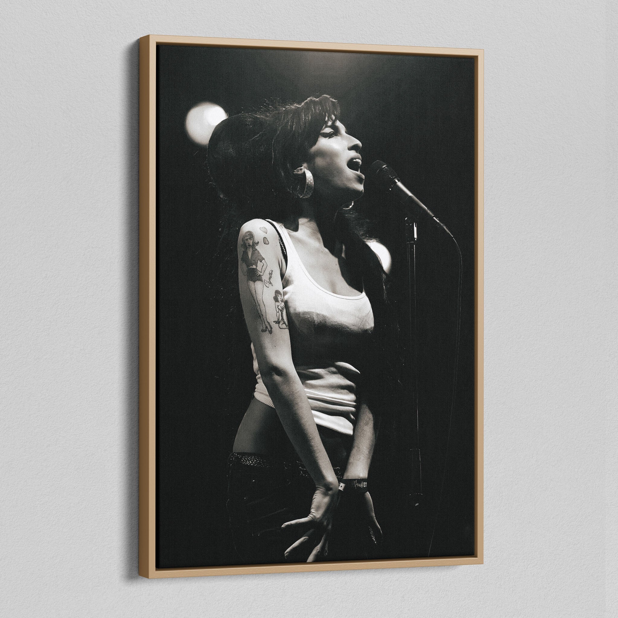 Angled view of the black and white canvas in a modern natural oak wood floating frame.