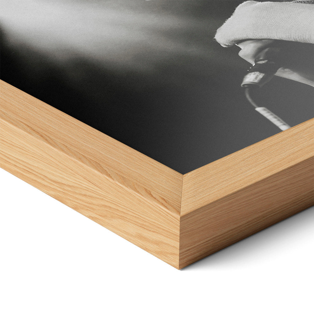 Corner close-up highlighting the natural oak finish of the framed Amy Winehouse 2007 black and white poster.