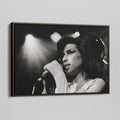 Angled view of the Amy Winehouse 2007 black and white canvas in a sophisticated dark walnut floating frame.