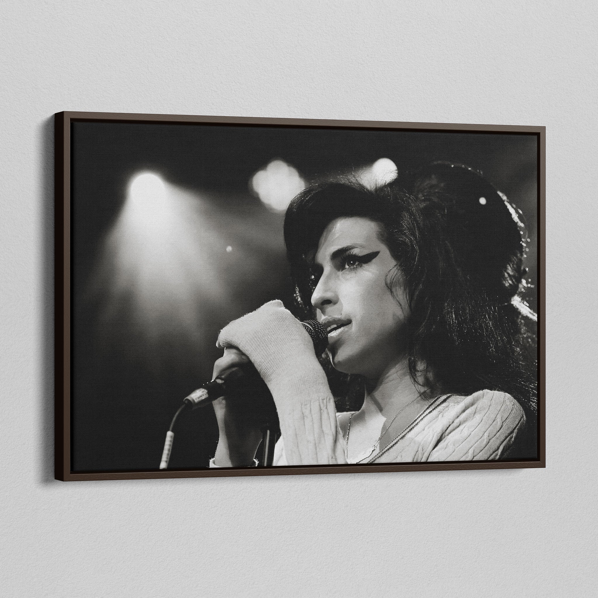 Angled view of the Amy Winehouse 2007 black and white canvas in a sophisticated dark walnut floating frame.