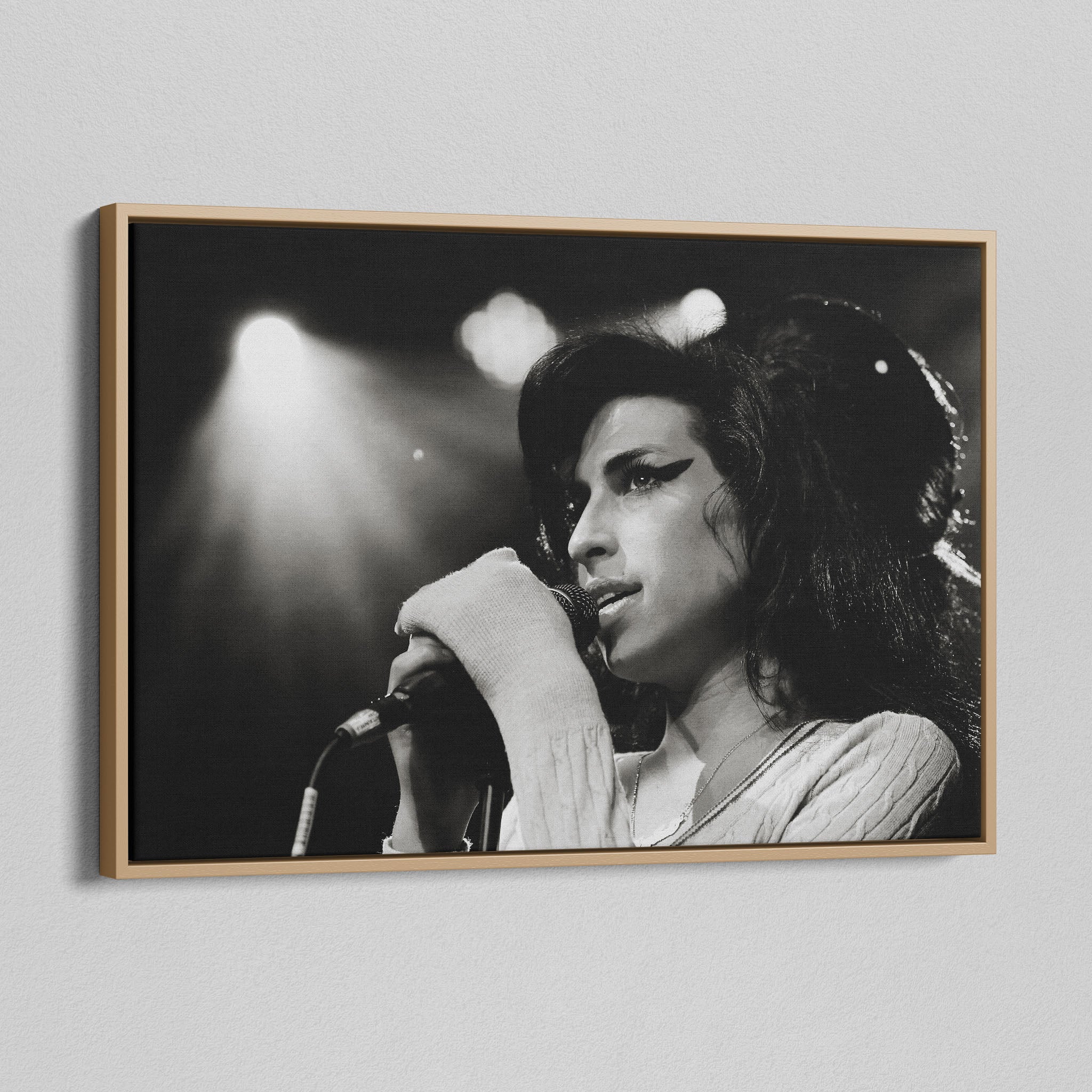 Angled view of the black and white canvas in a modern natural oak wood floating frame.