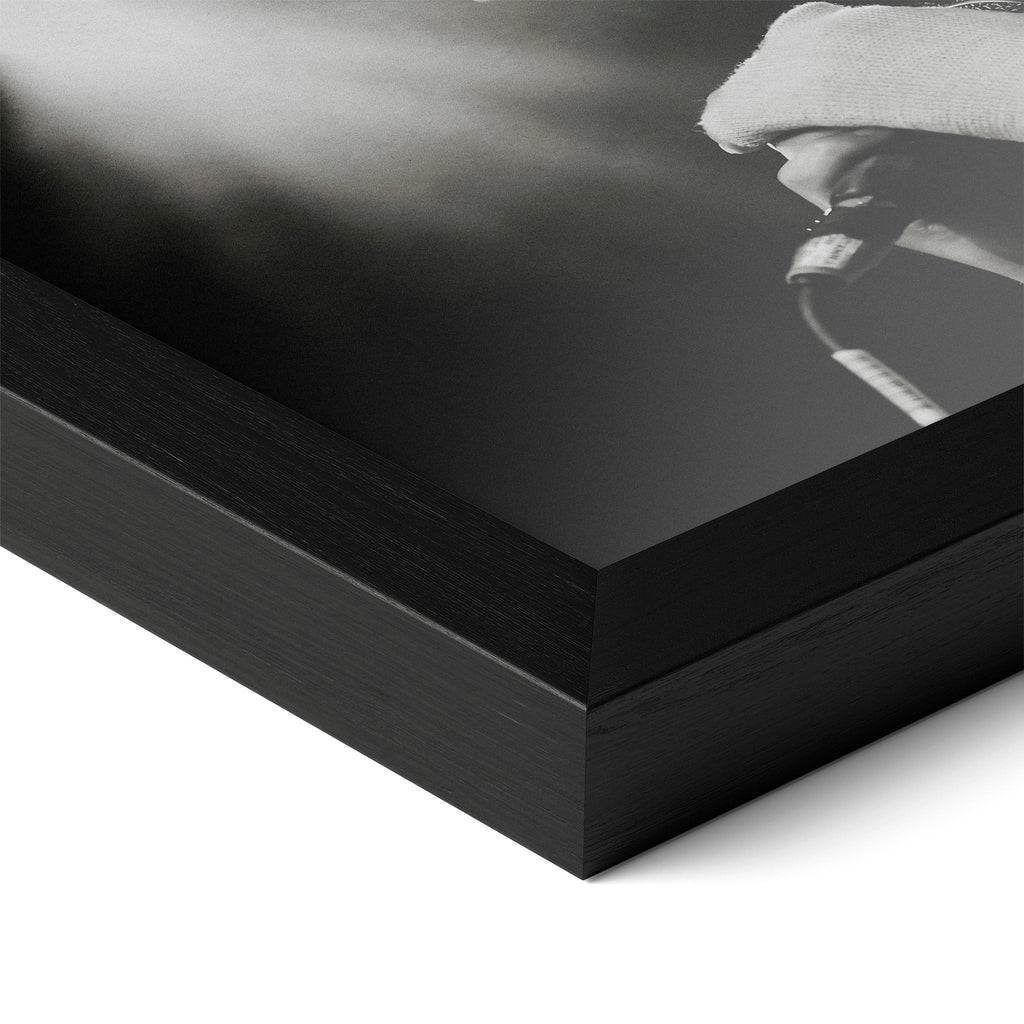 Detailed corner close-up of the premium black wooden frame holding the Amy Winehouse 2007 black and white concert poster.