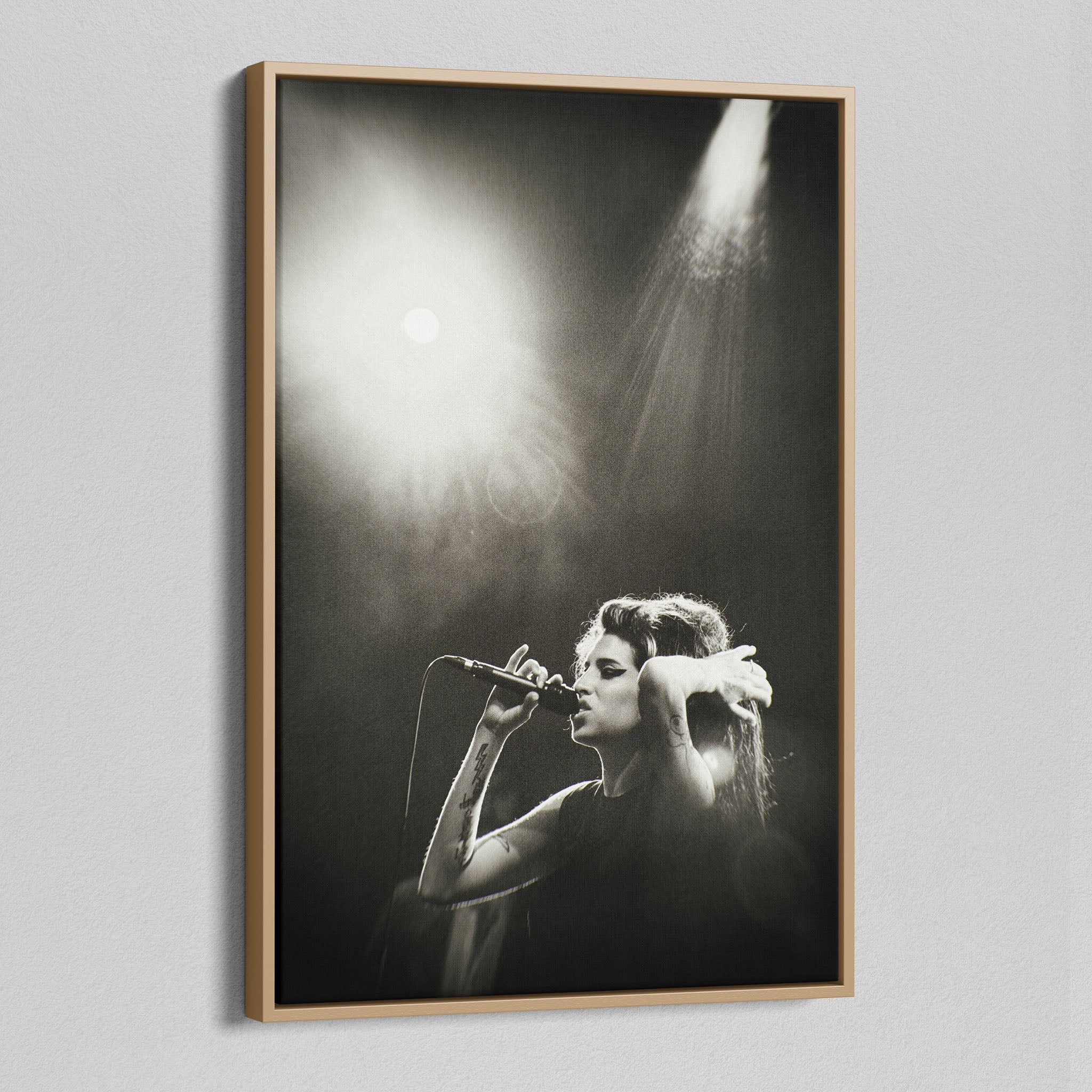 Angled view of the black and white canvas in a modern natural oak wood floating frame.