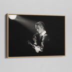 Angled view of the black and white canvas in a modern natural oak wood floating frame.