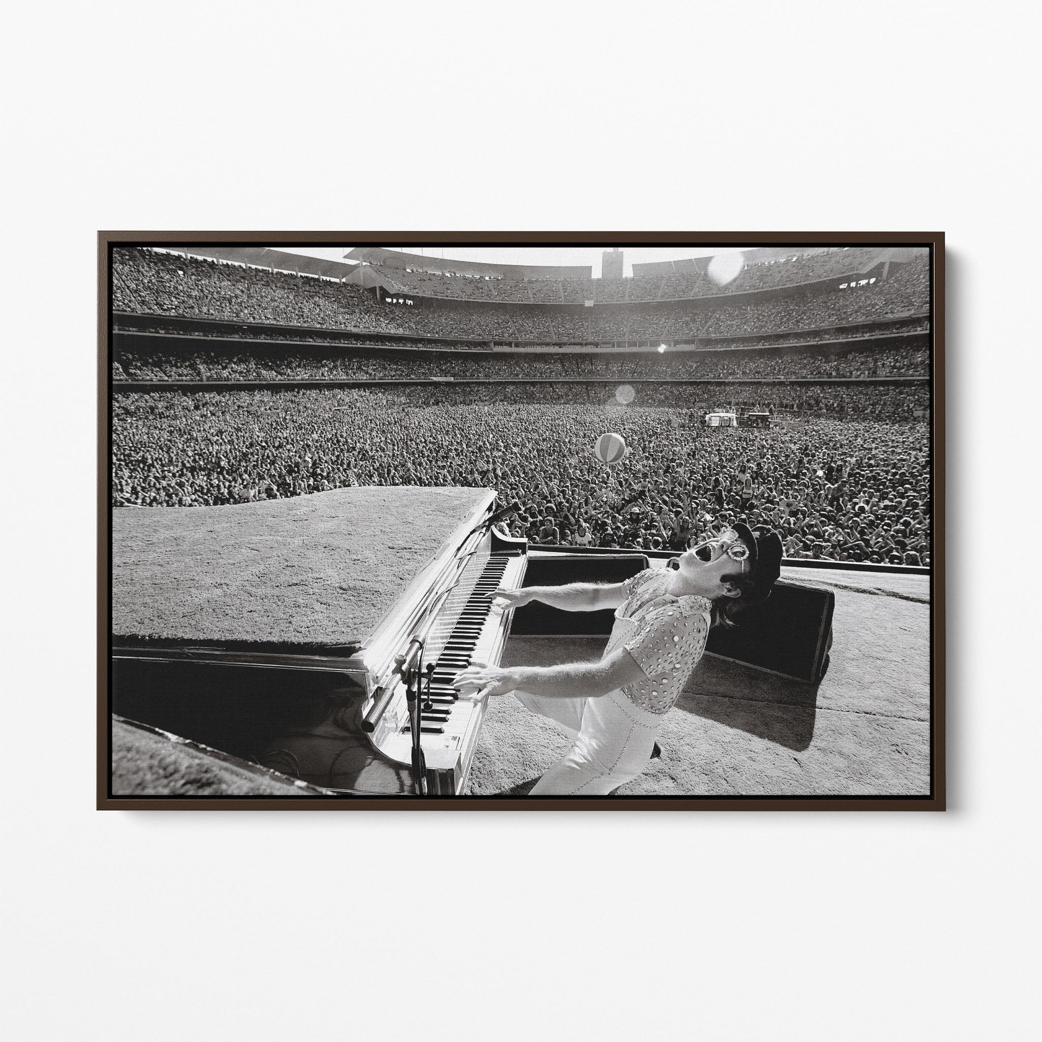 Front display of the Elton John 1975 black and white canvas in a premium dark walnut floating frame.