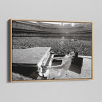Angled view of the black and white canvas in a modern natural oak wood floating frame.