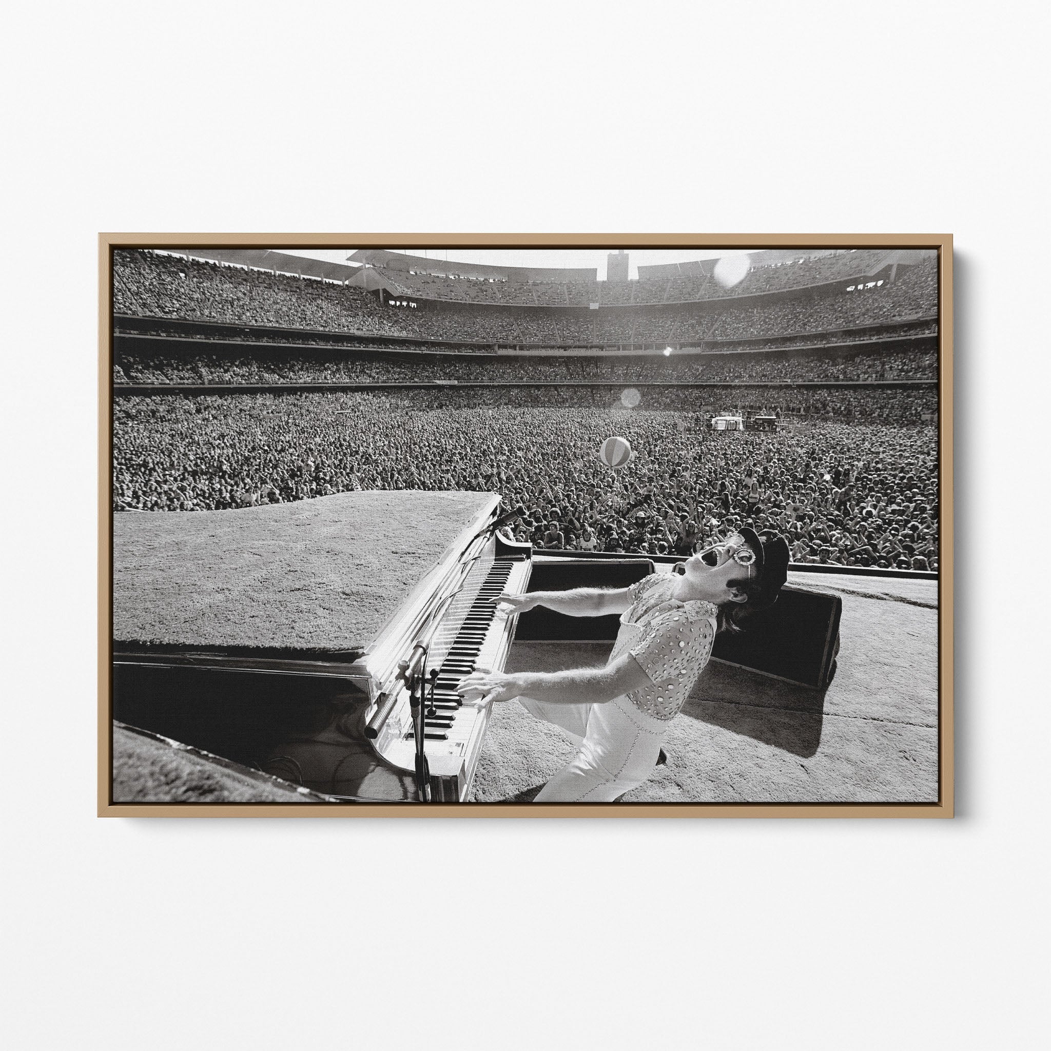 Front display of the Elton John 1975 black and white canvas in a premium natural wood floating frame.