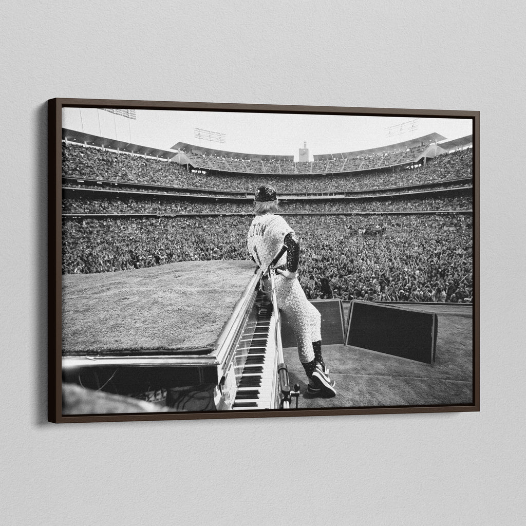 Angled view of the Elton John 1975 black and white canvas in a sophisticated dark walnut floating frame.