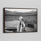 Angled view of the Elton John 1975 black and white canvas in a sophisticated dark walnut floating frame.