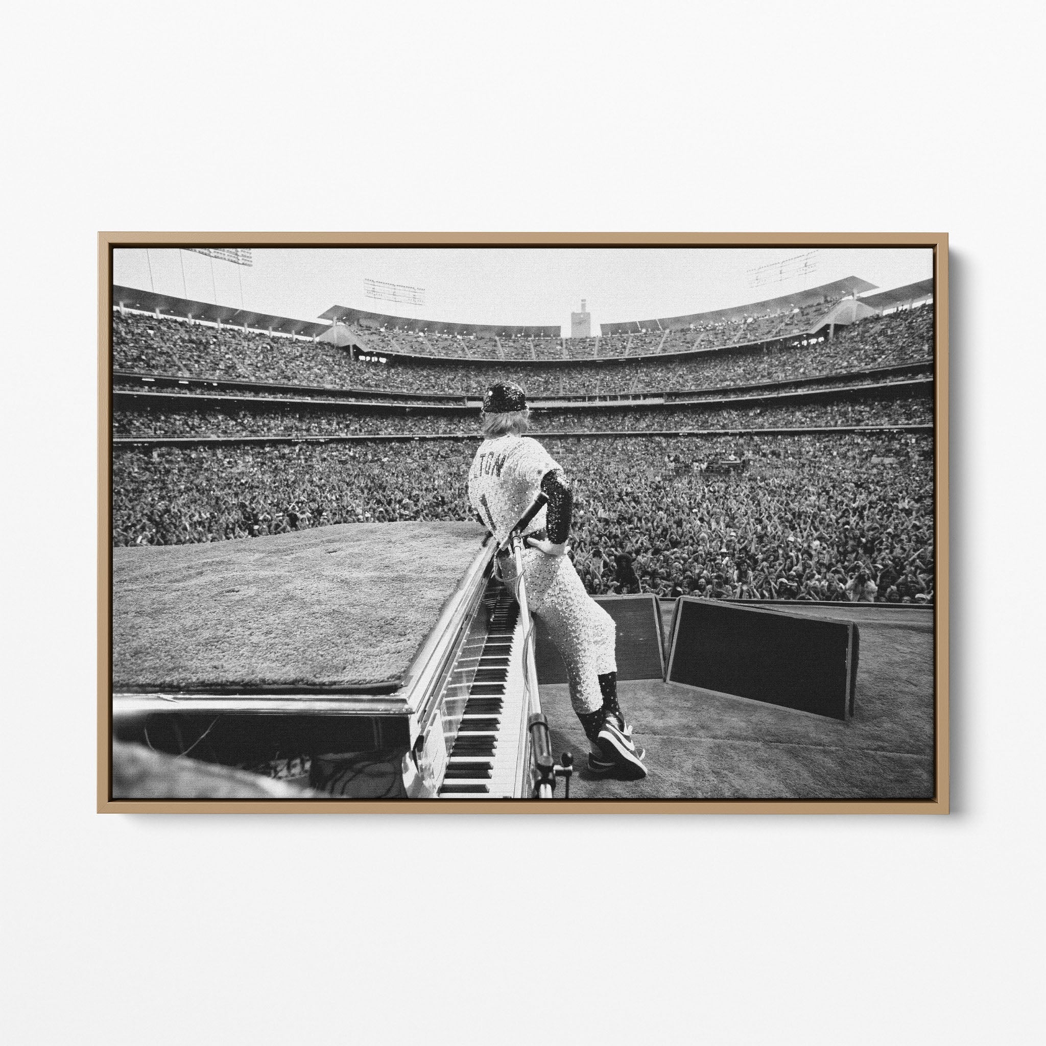 Front display of the Elton John 1975 black and white canvas in a premium natural wood floating frame.