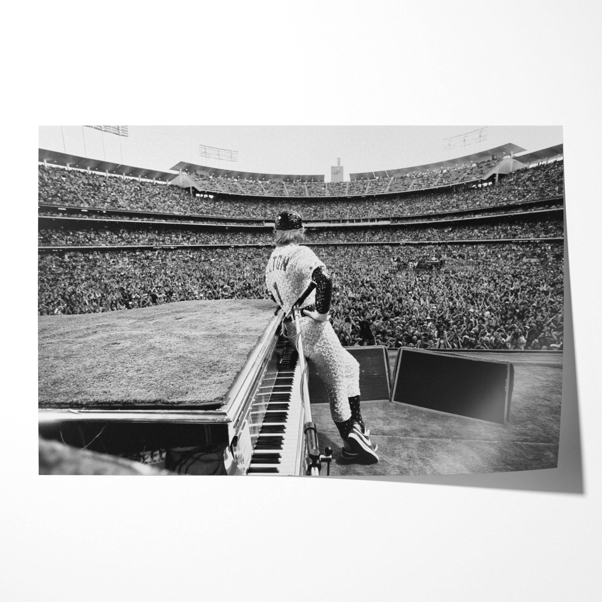 Unframed black and white Elton John 1975 Dodger Stadium concert poster print in his custom sequined baseball uniform behind the piano before 100,000 fans.