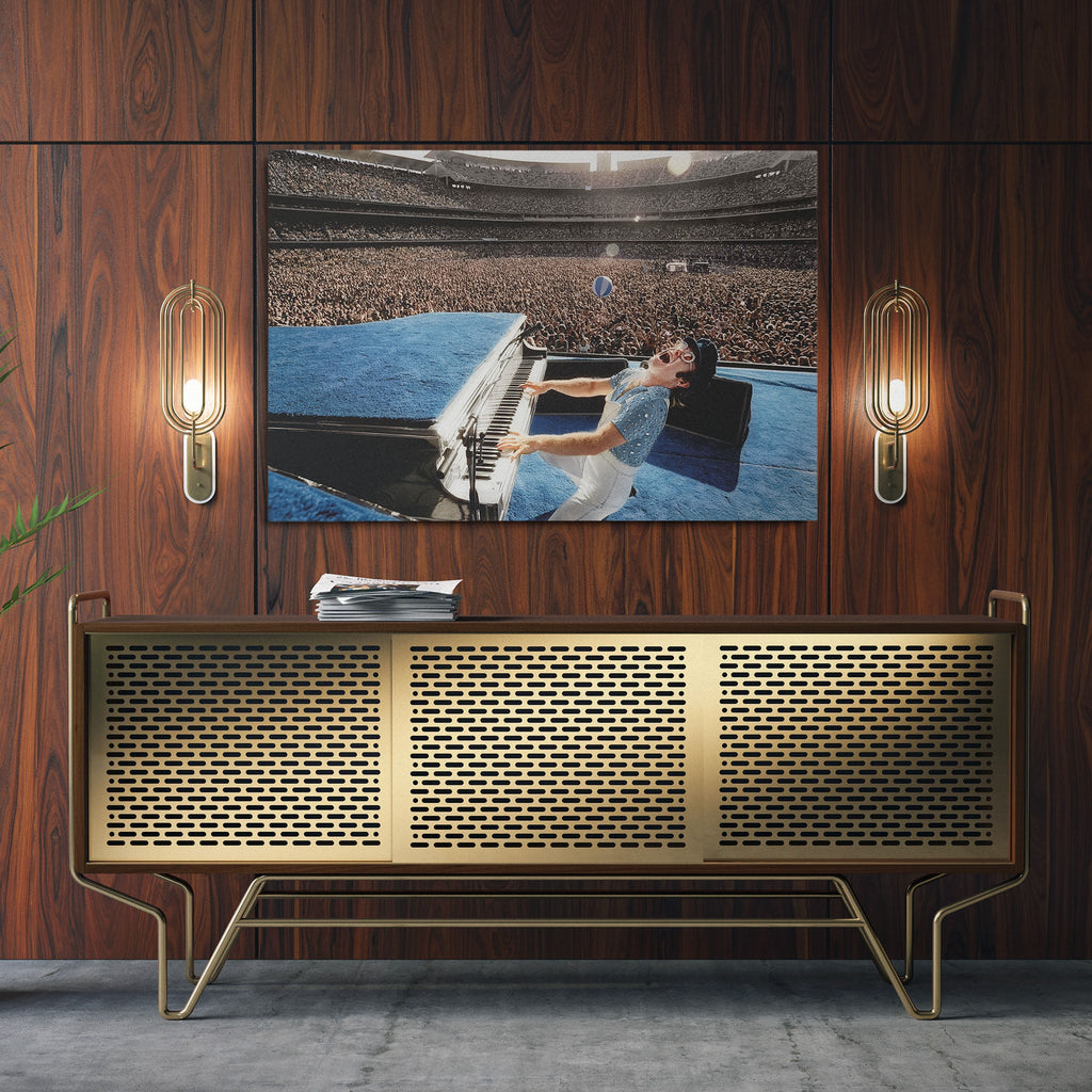 Sleek aluminum colorized metal print of Elton John displayed over a mid-century modern credenza.