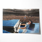 Unframed colour-enhanced Elton John 1975 Dodger Stadium poster print in his blue studded jumpsuit at the blue piano before 50,000 fans.