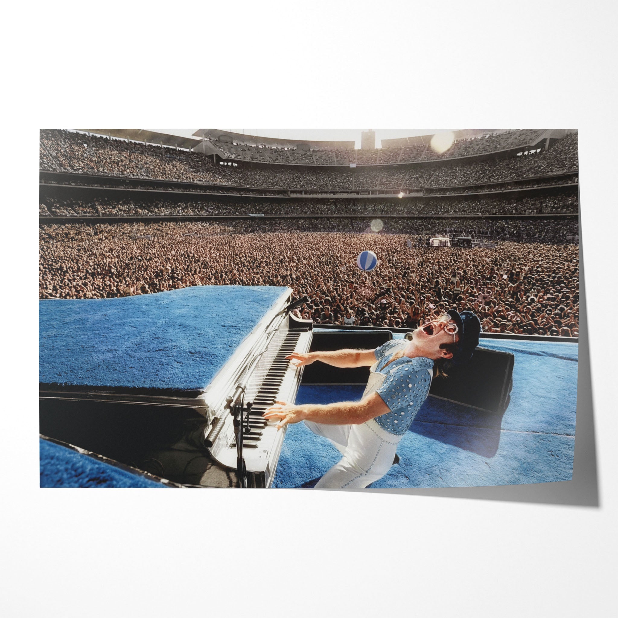 Unframed colour-enhanced Elton John 1975 Dodger Stadium poster print in his blue studded jumpsuit at the blue piano before 50,000 fans.