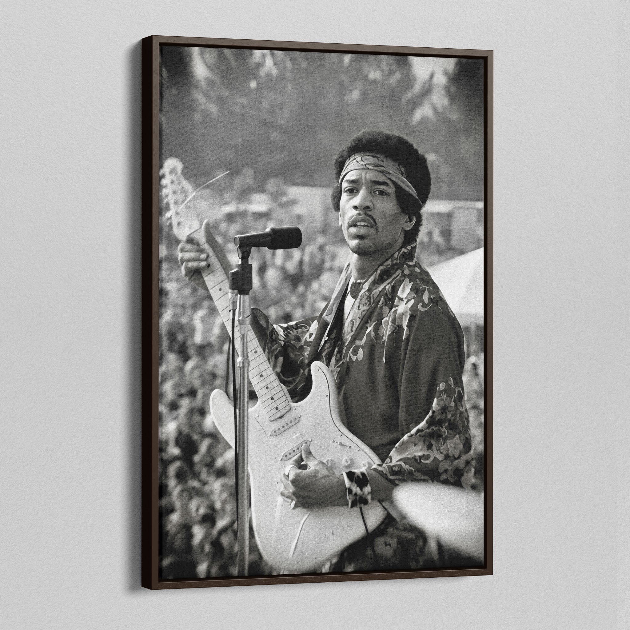 Angled view of the Jimi Hendrix black and white canvas in a dark walnut floating frame