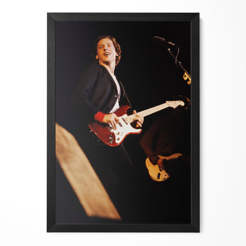Mark Knopfler on stage with his red guitar in 1980, color photo in a classic black poster frame