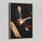 Angled view of the Mark Knopfler color canvas in a natural oak floating frame