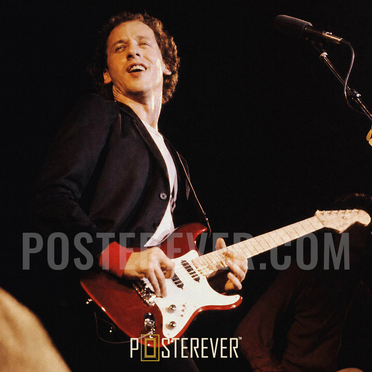 Zoomed detail of Mark Knopfler's red guitar and red wristband on stage, 1980