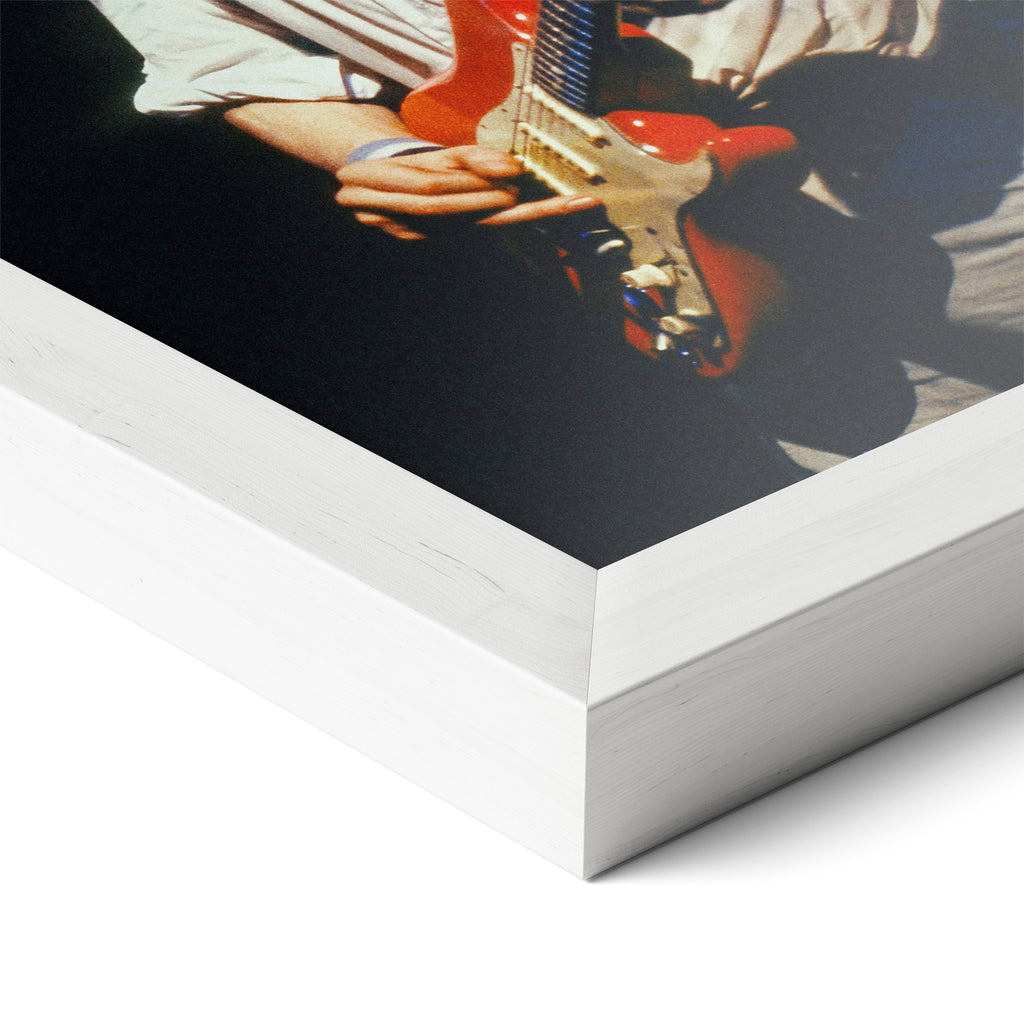 Corner close-up of the Mark Knopfler color poster in a white frame