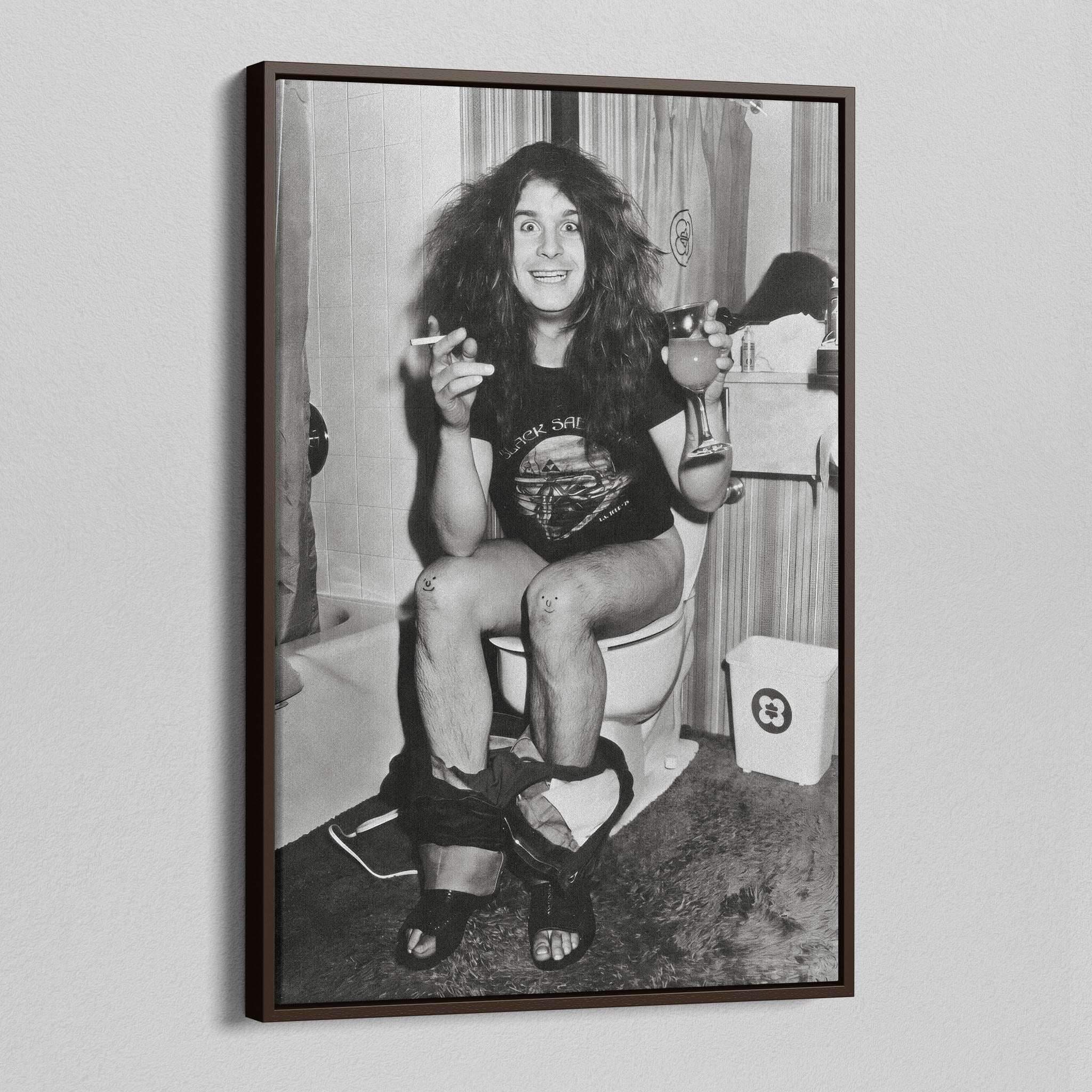 Angled view of the Ozzy Osbourne bathroom black and white canvas in a dark walnut floating frame