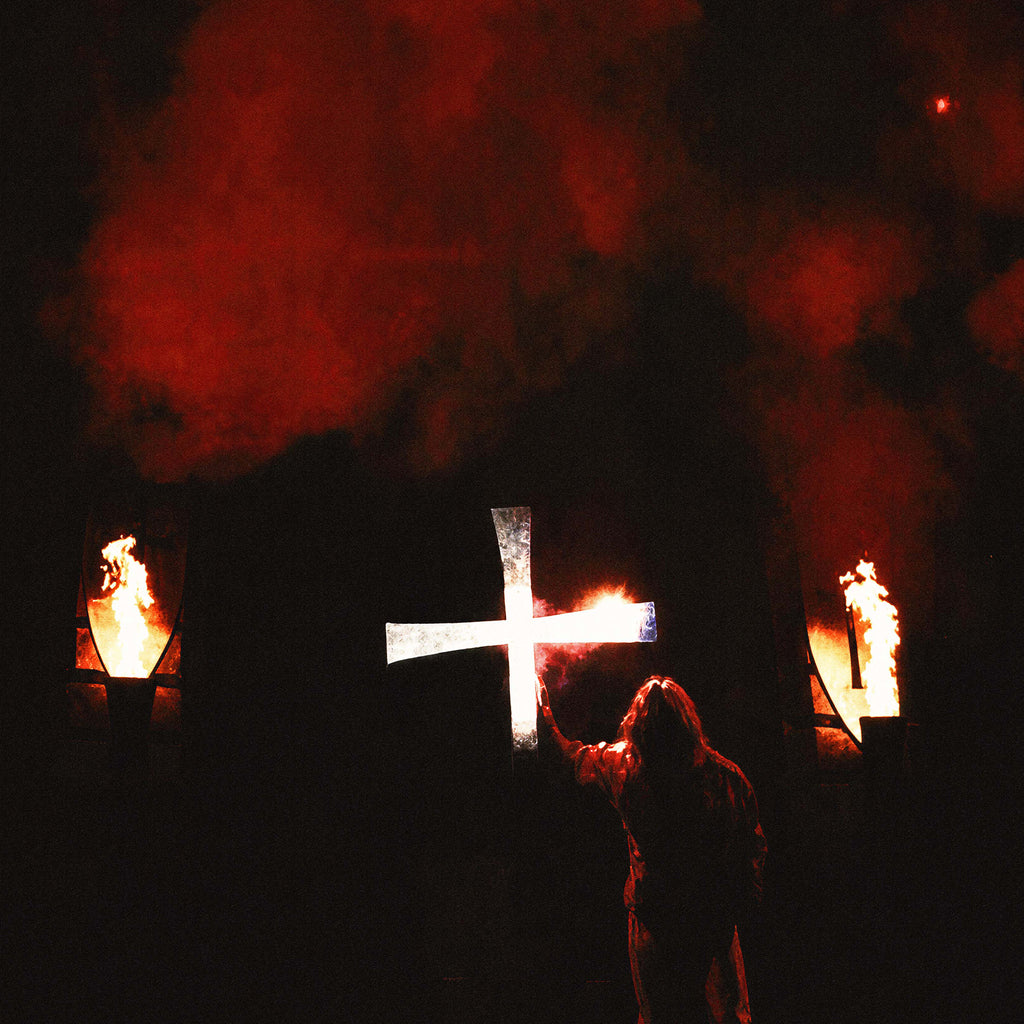 Zoomed detail of the blazing white cross and stage torches behind Ozzy Osbourne