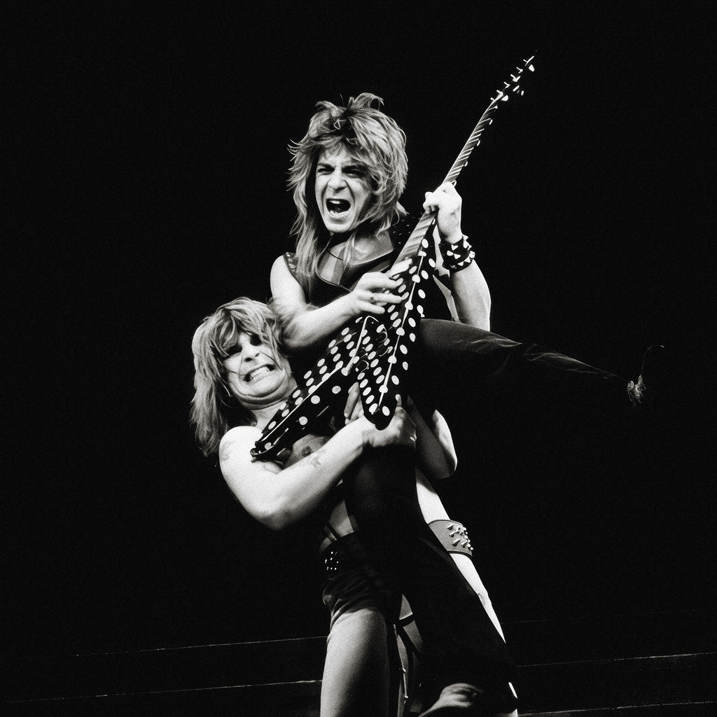 Zoomed detail of Randy Rhoads' polka-dot Flying V as Ozzy lifts him in black and white, 1982
