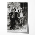 Unframed black and white print of Butch Cassidy and the Sundance Kid leaning against a stone wall