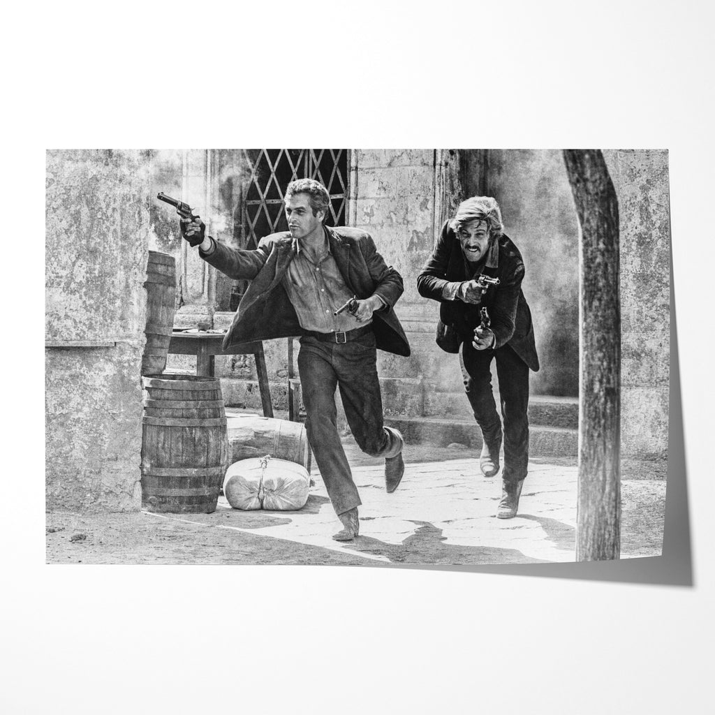 Unframed black and white print of Butch Cassidy and the Sundance Kid running out with revolvers drawn in the final shootout